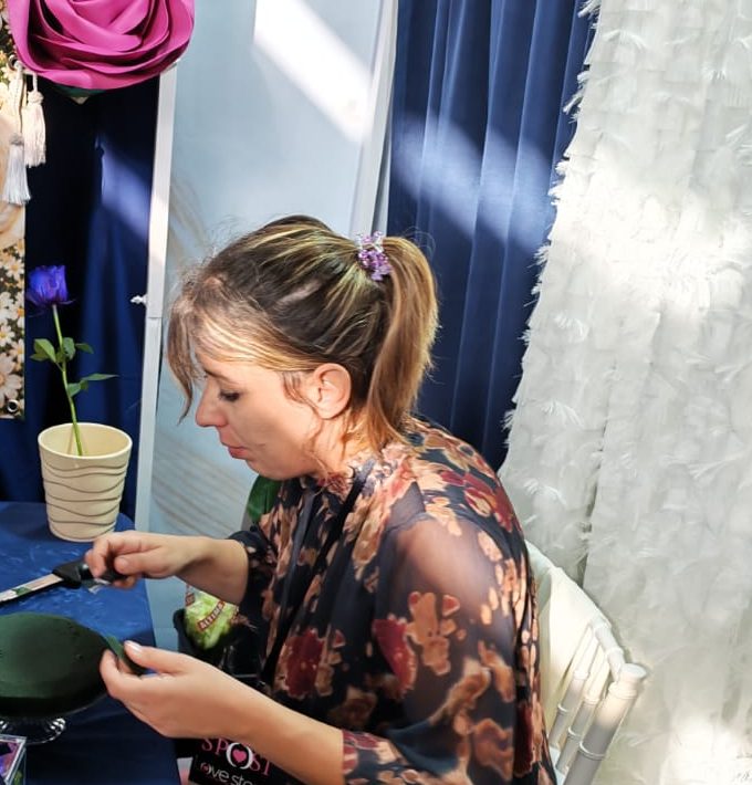 Caterina al lavoro su una composizione floreale durante la fiera